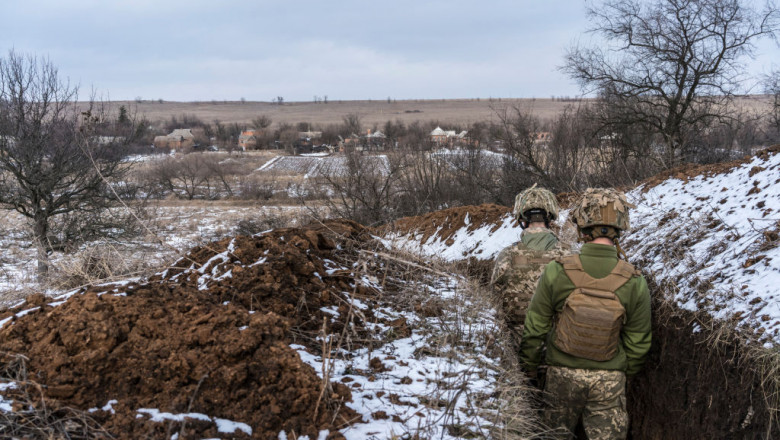 Militari ucraineni într-o tranșee, se uită spre orașul New York, din regiunea Donețk, Ucraina