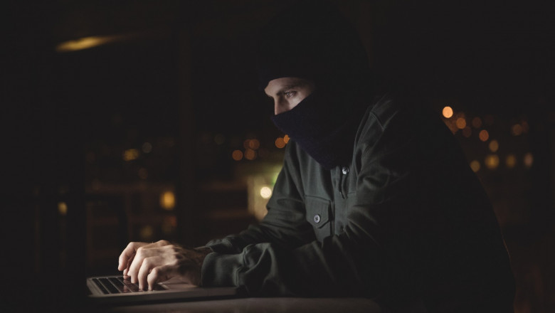 hacker cu cagula la laptop