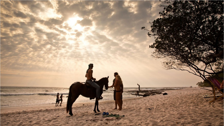oameni și un cal pe o plajă din Nicoya, Costa Rica