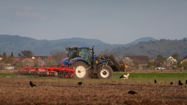 tractor cu plug ara un teren agricol