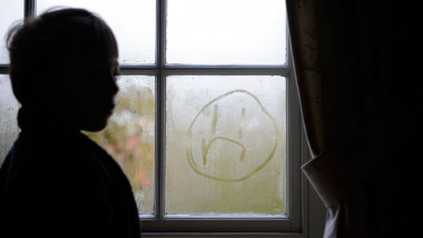 6 year old boy drawing a sad face 'on the window