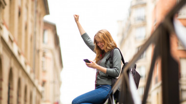 Side,Portrait,Of,Happy,Young,Woman,Looking,At,Mobile,Phone