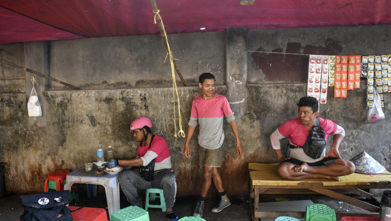 Delivery riders sit and rest at a street restaurant during a heatwave in Yangon on April 29, 2024