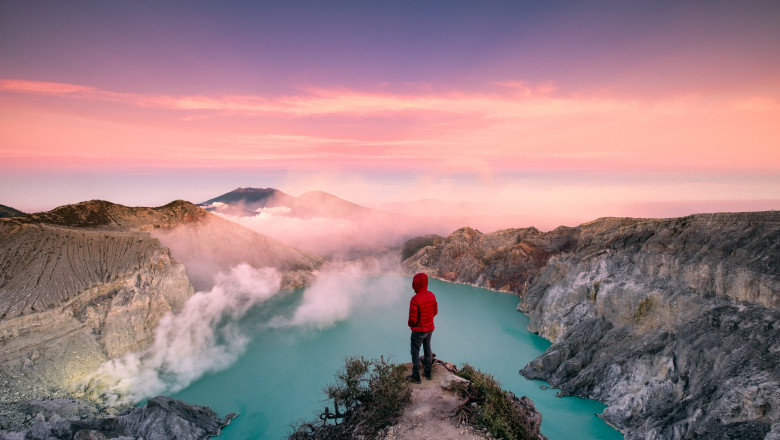 un om sta pe marginea unui lac vulcanic