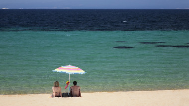 Couple under a parasol at the beach of Porto Puddu, Sardinia, Italy, Mediterranean, Europe