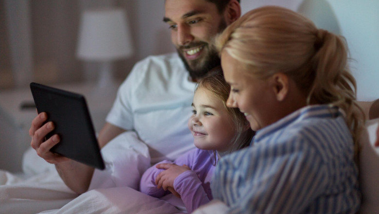 happy family with tablet pc in bed at home
