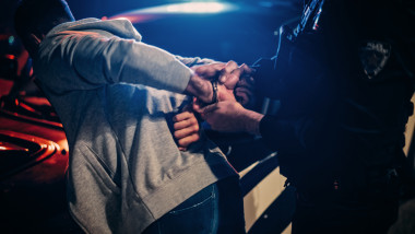 politist pune catusele unui barbat pe strada