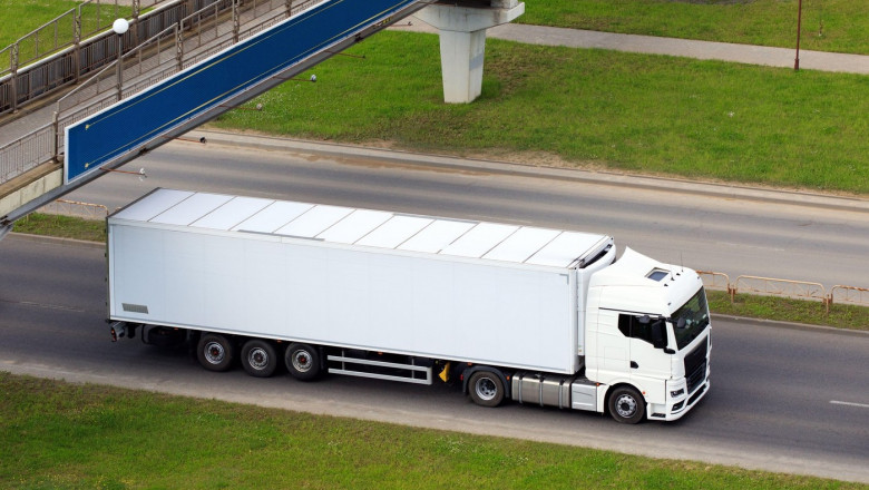 Truck cargo van on motorway under bridge in motion. Big commercial cargo van, freight car. Branding mockup.