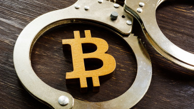 Fraud, ban and regulation of cryptocurrencies. Bitcoin sign and handcuffs.