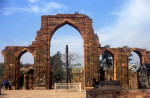 India: The remains of the Quwwat-ul-Islam Mosque and in the foreground the almost 2,000 year old Iron Pillar at the Qutb Minar complex, Delhi