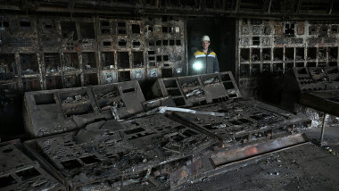 Un muncitor se plimbă printre ruinele unei camere de control a unei centrale electrice distruse de bombardamentele ruse în Ucraina