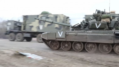 un tanc cu simbolul „V” trece pe lângă un camion al armatei ruse pe frontul de la Harkov