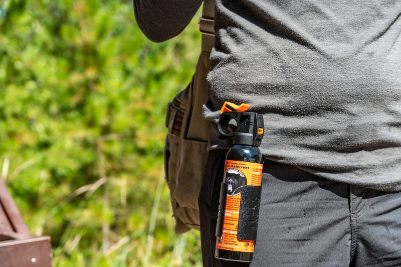 Apgar, Montana, USA - 8.2022 - Can of aerosol bear spray being worn on a hiker's belt.