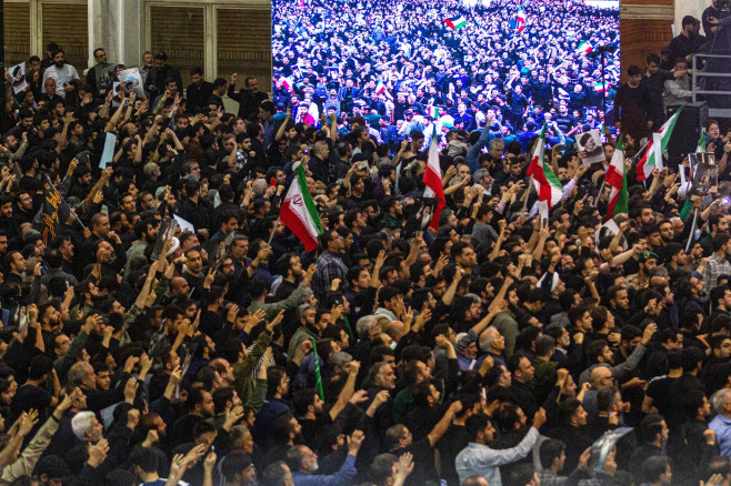 Iranian officials adjust the coffin of late President Ebrahim Raisi during a funeral procession ceremony at the Mossalla