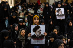 Iranian officials adjust the coffin of late President Ebrahim Raisi during a funeral procession ceremony at the Mossalla