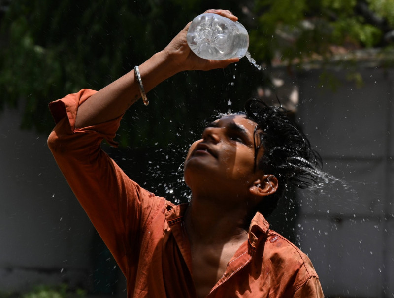 NEW DELHI, INDIA - MAY 29: A boy sprays water to get some relief from heat wave on a hot summer afternoon on May 29, 202