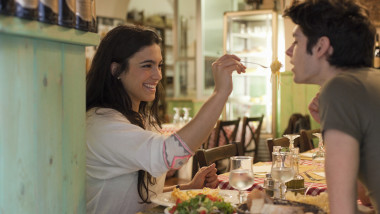 happy young couple eating together in restaurant
