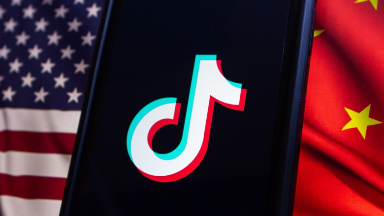 Vancouver, CANADA - Apr 30 2024 : TikTok logo seen in an iPhone screen on American flag and Chinese flag background