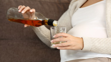 gravida cu sticla cu alcool in mana