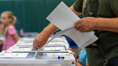 un barbat introduce voturile in urna