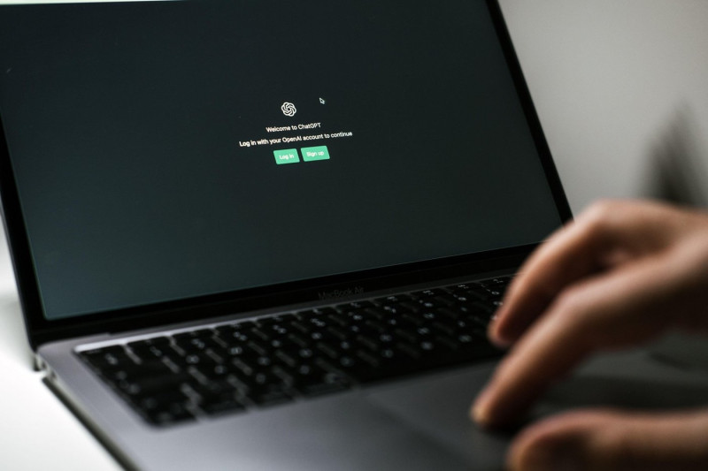 Screen with ChatGPT chat with AI or artificial intelligence. Man search for information using artificial intelligence chatbot developed by OpenAI