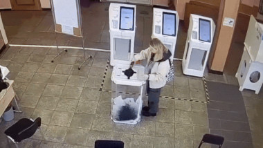 o femeie toarna vopsea intr-o urna la alegerile prezidentiale din rusia