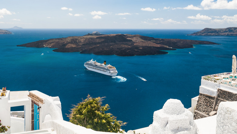 imagine cu o nava de croaziera langa insula santorini