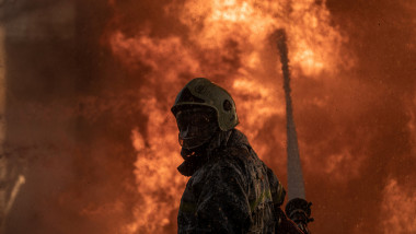 pompier care încearcă să oprească un foc declanșat de un atac aerian al Rusiei în Kiev