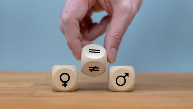Symbol for gender equality. Hand turns a dice and changes a unequal sign to a equal sign between symbols of men and women.