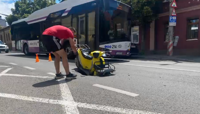 Scuter înghițit pe jumătate de o groapă uriașă nesemnalizată, pe o stradă din Cluj Napoca 