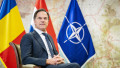 Mark Rutte stă pe scaun cu steagurile României, Olandei și NATO în spate
