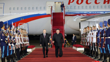Kim Jong Un (centre R) walking with Russia's President Vladimir Putin (centre L) past an honour guard upon the latter's arrival at Pyongyang International Airport