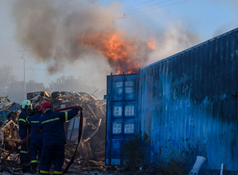 Athens, Greece. 19 June 2024. Firefighters attempt to extinguish the fire that has broke out in a factory area during a wildfire in the eastern suburbs of the Greek capital. Authorities have urged residents to evacuate an area on the fringes of Athens whe