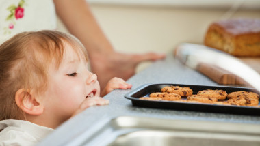 un copil se uita la prajiturile abia scoase din cuptor