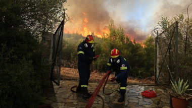 pompieri care intind furtunul pentr a stinge incendiul in grecia