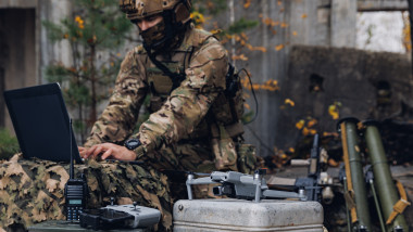 un militar ucrainean care transmite informații printr-un laptop