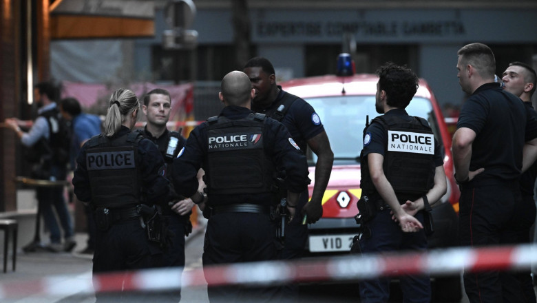 Police officers stand next to rescue vehicles near the bar "Le Ramus" (back) where a motorist drove onto the terrace of a cafe, leaving several injured