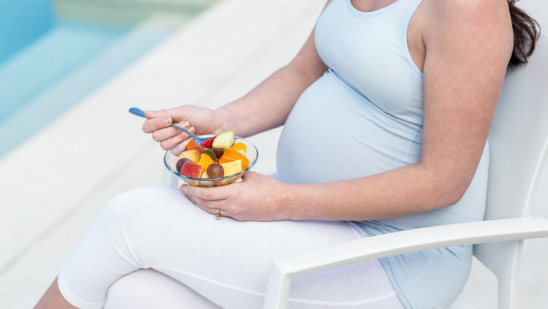 Pregnant woman eating fruit