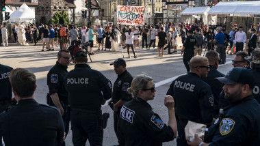 polițiști în fața unor protestatari cu pancarte anti trump