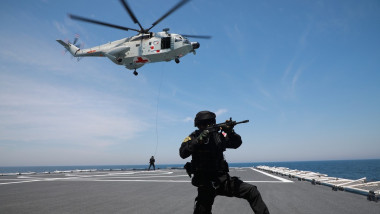 A crew member of Chinese People's Liberation Army (PLA) Navy hospital ship "Peace Ark" is pictured during a tactics training session on the deck, helicoppter flying