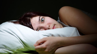 Young woman in bed eyes opened suffering insomnia. Nightmare issues