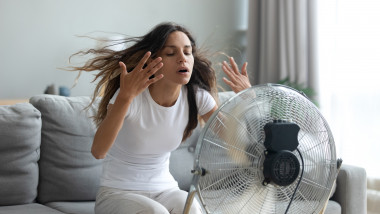 femeie care sta in fata unui ventilator