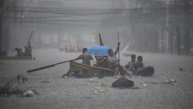 Rescuers paddle their boats along a flooded street in Manila on July 24, 2024 amid heavy rains brought by Typhoon Gaemi