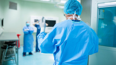 Rear view of surgeon walking in operation room at hospital