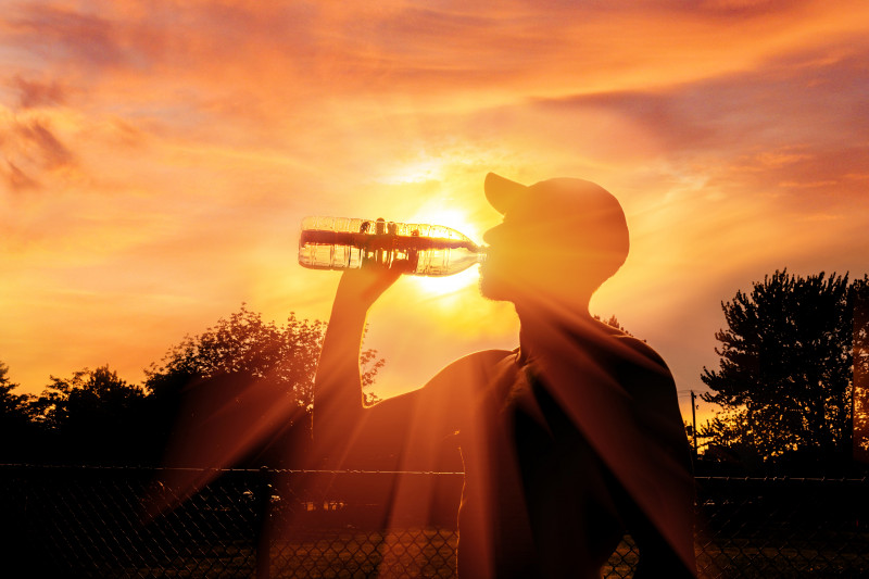 Silhouette,Of,A,Man,Drinking,Water,During,Heat,Wave