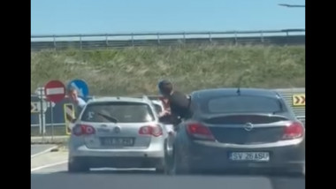 soferii a doua masini se sicaneaza in trafic, pasagerii iesiti pe geam