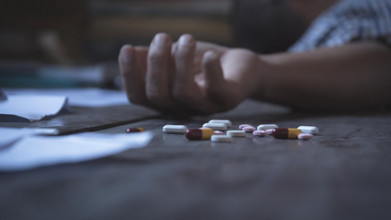 The man committing suicide by overdosing on medication. Close up of overdose pills and addict.