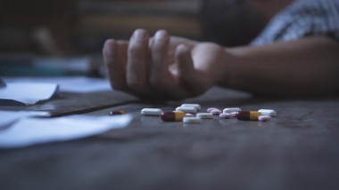 The man committing suicide by overdosing on medication. Close up of overdose pills and addict.