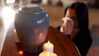 woman with cremation urn at funeral in church