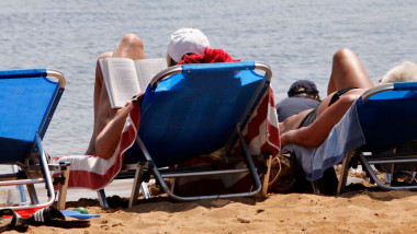 turisti pe sezlong la mare